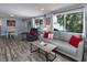 Bright living room with large windows and comfortable seating, seamlessly connecting to the dining area at 2933 Stratford Dr, Largo, FL 33771