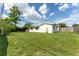 Back of home view showing green grass yard and bright blue sky at 3300 58Th N St, St Petersburg, FL 33710