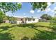 View of the back of the home, with a grass yard and bench on the patio at 3300 58Th N St, St Petersburg, FL 33710