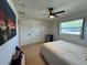 Bedroom with closet, wood-look floors, ceiling fan, and a window offering natural light for a restful retreat at 3300 58Th N St, St Petersburg, FL 33710