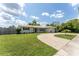 Beautiful single-story home boasting a lush green lawn, curved driveway, and charming curb appeal, perfect for a Gathering at 3300 58Th N St, St Petersburg, FL 33710
