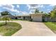 Charming single-story home with well-manicured lawn and circular driveway leading to an attached garage at 3300 58Th N St, St Petersburg, FL 33710