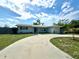 Inviting single-story home showcasing a circular driveway, lush lawn, and a well-manicured palm tree at 3300 58Th N St, St Petersburg, FL 33710