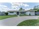 Charming single-story home with well-manicured lawn and circular driveway leading to an attached garage at 3300 58Th N St, St Petersburg, FL 33710