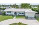 Charming single-story home featuring a well-manicured lawn and a circular driveway leading to an attached garage at 3300 58Th N St, St Petersburg, FL 33710