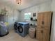 Bright laundry room with updated washer and dryer and a storage cabinet at 3300 58Th N St, St Petersburg, FL 33710