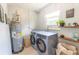 Functional laundry room featuring modern washer and dryer, shelving, and large window at 3300 58Th N St, St Petersburg, FL 33710