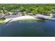 Scenic aerial view of a lake community beach, boat launch, pier, and parking area surrounded by lush greenery at 3304 Latania Dr, Tampa, FL 33618