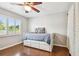Well-lit bedroom featuring a bright window with shutters and hardwood floors at 3304 Latania Dr, Tampa, FL 33618