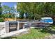 Outdoor grilling and picnic area near a sandy volleyball court with lake views in a lush, private community at 3304 Latania Dr, Tampa, FL 33618