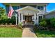 Inviting front entrance featuring a covered porch, double doors, decorative flower pots, and lush landscaping at 3304 Latania Dr, Tampa, FL 33618
