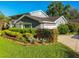 Charming two-story home with a well-manicured lawn, colorful flower beds, and mature landscaping at 3304 Latania Dr, Tampa, FL 33618