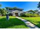 Charming two-story home with landscaped yard and walkway leading to the entrance, all under a clear blue sky at 3304 Latania Dr, Tampa, FL 33618