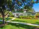 Charming two-story home with manicured lawn, mature trees, and vibrant landscaping creating great curb appeal at 3304 Latania Dr, Tampa, FL 33618