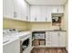 Bright laundry room featuring white cabinetry, granite countertops, and modern appliances at 3304 Latania Dr, Tampa, FL 33618