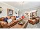 Comfortable living room featuring a leather sofa, ottoman, decorative pillows, and a stylish rug at 3304 Latania Dr, Tampa, FL 33618