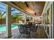 Relaxing covered patio featuring brick pavers, ceiling fans, and a dining area near the sparkling screened-in pool at 3304 Latania Dr, Tampa, FL 33618