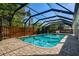 Beautiful screened-in pool with brick paver decking, complemented by mature landscaping and a privacy fence at 3304 Latania Dr, Tampa, FL 33618