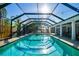 Beautiful screened-in pool with brick paver decking, complemented by mature landscaping and a privacy fence at 3304 Latania Dr, Tampa, FL 33618