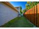 Well-maintained side yard featuring artificial turf, a privacy fence, and access to an outdoor A/C unit at 3304 Latania Dr, Tampa, FL 33618