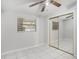 Bedroom with tile floors, a ceiling fan, a window with blinds, and mirrored closet doors at 3308 W Walnut St, Tampa, FL 33607