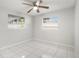 Bright bedroom featuring tile flooring, a ceiling fan, and two large windows at 3308 W Walnut St, Tampa, FL 33607