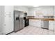 Well-lit kitchen with white cabinets, stainless steel appliances, and tiled floors at 3308 W Walnut St, Tampa, FL 33607