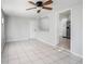 Bright living room featuring tile flooring, a ceiling fan, and an open view of the kitchen at 3308 W Walnut St, Tampa, FL 33607