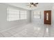 Bright living room featuring tile flooring, a ceiling fan, large windows, and a wooden front door at 3308 W Walnut St, Tampa, FL 33607