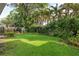 Green backyard featuring lush landscaping, playhouse, and mature trees at 3619 W Leona St, Tampa, FL 33629