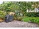Private backyard featuring a brick patio, lush landscaping, and a covered barbeque at 3619 W Leona St, Tampa, FL 33629