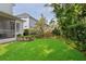 Well-maintained backyard with expansive lawn, screened porch, and lush, tropical landscaping at 3619 W Leona St, Tampa, FL 33629