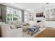 Bright living room features a fireplace, built-in shelving, and large windows with views of lush greenery at 3619 W Leona St, Tampa, FL 33629