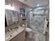 Bathroom features a glass door shower, marble-patterned floor and wall tiles and a vanity with granite countertop at 37535 Laurel Hammock Dr, Zephyrhills, FL 33541
