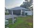 Charming single-story home with a well-maintained lawn, dark garage door, and white picket fence at 37535 Laurel Hammock Dr, Zephyrhills, FL 33541