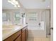 Bright bathroom with double vanity, soaking tub, and glass-enclosed shower at 396 Winthrop Dr, Spring Hill, FL 34609