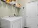 Laundry room featuring a modern washer and dryer, with functional shelving for storage, with door to the exterior at 396 Winthrop Dr, Spring Hill, FL 34609