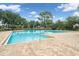 Beautiful community pool with a brick deck, featuring clear blue water and surrounding greenery at 396 Winthrop Dr, Spring Hill, FL 34609