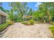 Paver patio with a pergola surrounded by lush landscaping at 401 Whitcomb Blvd, Tarpon Springs, FL 34689