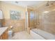 Bathroom features a glass-enclosed shower over tub, a window, and tile flooring at 401 Whitcomb Blvd, Tarpon Springs, FL 34689