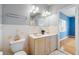 Bright bathroom featuring double sink vanity, toilet and view into bedroom with hardwood flooring at 401 Whitcomb Blvd, Tarpon Springs, FL 34689