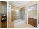 Bathroom with glass-enclosed shower-tub combo and access to bedroom at 401 Whitcomb Blvd, Tarpon Springs, FL 34689