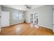 Bright bedroom with hardwood floors, ceiling fan, and access to a screened porch with views of the water at 401 Whitcomb Blvd, Tarpon Springs, FL 34689