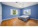 Bright bedroom with hardwood floors, two windows, ceiling fan and light blue walls at 401 Whitcomb Blvd, Tarpon Springs, FL 34689
