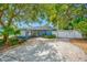 Charming home with carport, well-maintained landscaping, and a privacy fence, enhancing curb appeal at 401 Whitcomb Blvd, Tarpon Springs, FL 34689