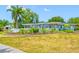 Beautiful single Gathering home with well-manicured lawn, mature landscaping, and a decorative white fence along the front of the property at 401 Whitcomb Blvd, Tarpon Springs, FL 34689