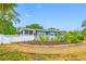 A quaint single-story home with manicured landscaping, a white picket fence, and charming curb appeal at 401 Whitcomb Blvd, Tarpon Springs, FL 34689