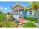 Cozy front porch with painted steps, vibrant landscaping, and a charming front entry door, offering curb appeal and warmth at 401 Whitcomb Blvd, Tarpon Springs, FL 34689