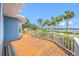 Inviting front porch with wooden flooring, decorative railings, and picturesque views of the waterfront and palm-lined street at 401 Whitcomb Blvd, Tarpon Springs, FL 34689