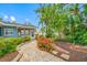 Lush landscaping and a stone path lead to the screened-in porch of this charming blue home at 401 Whitcomb Blvd, Tarpon Springs, FL 34689